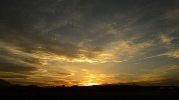 vliegtuig aankomen en landen in landschap Bij zonsondergang met wolken in de lucht video