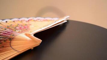 Traditional hand fan decorated with flowers and made in wood gyrating video