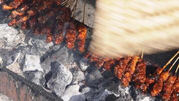 Chicken satay on fiery charcoal grilling by people in Indonesia video