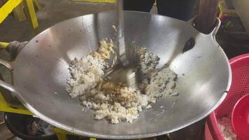 närbild skott av en kock matlagning friterad ris i en varm wok på en spis med brand. video