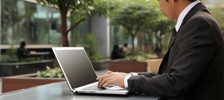 AI generated Smiling mature businessman working on laptop computer with copy space for text placement. photo