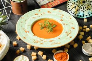 Carrot Soup With Croutons on Table photo