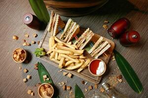 Wooden Cutting Board With Halved Sandwich and French Fries photo