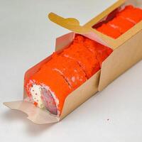Sushi rodar en cartulina caja en un de madera mesa foto