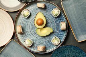 azul plato con palta, rodeado por otro platos foto