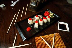 negro plato con Sushi y palillos foto