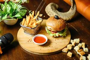 Delicious Hamburger and French Fries on Wooden Table photo