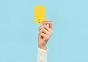 A female hand holds a payment card on a blue background. Online service. photo