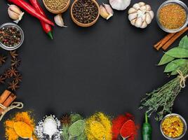 A variety of spices and herbs on a dark table. Cooking background. View from above. Ingredients for cooking. Table background menu. Copy space. photo