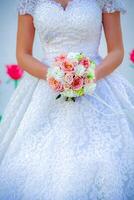 Woman in Wedding Dress Holding Bouquet of Flowers photo