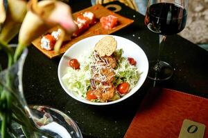 delicioso plato de comida y vaso de vino en mesa foto