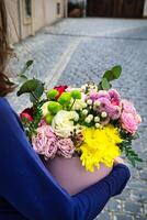 Woman Holding Bouquet of Flowers on Cobblestone Street photo