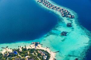 Fantastic aerial landscape, luxury tropical resort or hotel with water villas and beautiful beach scenic. Amazing bird eyes view in Maldives, landscape seascape aerial view over Maldives, traveling photo