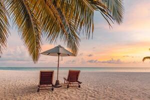 Tranquil sea sand sunset sky relaxing beach. Love couple romantic freedom travel tourism landscape. Idyllic exotic chairs umbrella, palm tree leaves, tropics beachfront resort. Summer vacation island photo