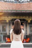 woman traveler visiting in Taiwan, Tourist with hat sightseeing in Longshan Temple, Chinese folk religious temple in Wanhua District, Taipei City. landmark and popular. Travel and Vacation concept photo