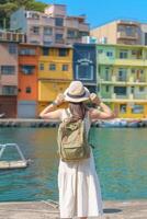 mujer viajero visitando en Taiwán, turista con mochila y sombrero Turismo en quilla, vistoso zhengbin pescar puerto, punto de referencia y popular atracciones cerca taipei ciudad . Asia viaje concepto foto