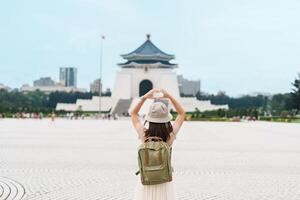 mujer viajero visitando en Taiwán, turista con mochila Turismo en nacional chiang kai shek monumento o salón libertad cuadrado, taipei ciudad. punto de referencia y popular atracciones Asia viaje concepto foto