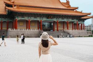 mujer viajero visitando en Taiwán, turista con sombrero Turismo en nacional chiang kai shek monumento o salón libertad cuadrado, taipei ciudad. punto de referencia y popular atracciones Asia viaje concepto foto