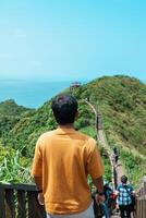 man traveler visiting in Taiwan, Tourist sightseeing in Bitou Cape Hiking Trail, New Taipei City. landmark and popular attractions near Taipei. Asia Travel concept photo
