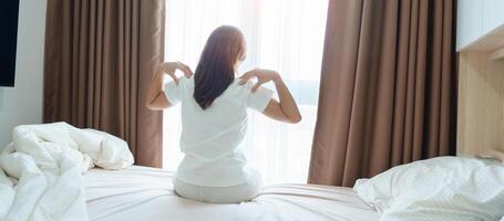 Woman having Shoulder and Neck pain during sitting on bed at home. Muscle painful due to Myofascial pain syndrome and Fibromyalgia, rheumatism, Scapular pain, Cervical Spine. Waking and Health concept photo