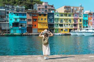 mujer viajero visitando en Taiwán, turista con mochila y sombrero Turismo en quilla, vistoso zhengbin pescar puerto, punto de referencia y popular atracciones cerca taipei ciudad . Asia viaje concepto foto