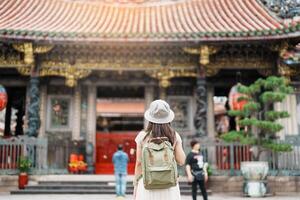 mujer viajero visitando en Taiwán, turista con sombrero Turismo en Longshan templo, chino gente religioso templo en Wanhua distrito, taipei ciudad. punto de referencia y popular. viaje y vacaciones concepto foto