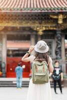 mujer viajero visitando en Taiwán, turista con sombrero Turismo en Longshan templo, chino gente religioso templo en Wanhua distrito, taipei ciudad. punto de referencia y popular. viaje y vacaciones concepto foto