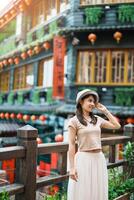 mujer viajero visitando en Taiwán, turista con sombrero Turismo en jiufen antiguo calle pueblo con té casa antecedentes. punto de referencia y popular atracciones cerca taipei ciudad . viaje y vacaciones concepto foto