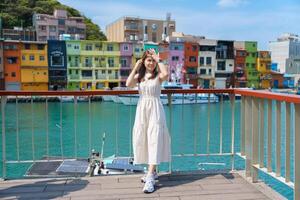 woman traveler visiting in Taiwan, Tourist with hat sightseeing in Keelung, Colorful Zhengbin Fishing Port, landmark and popular attractions near Taipei city . Asia Travel concept photo