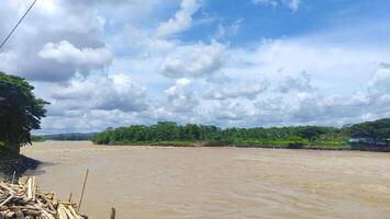 view of serayu river with big current, river landscape at day photo