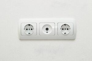 Sockets in the wall together with an input for an antenna for television. photo