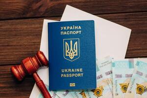 Ukrainian hryvnia money on the table with documents with a place for text and a passport to Ukraine. photo