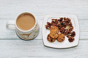 Healthy breakfast oat round granola with nuts on a plate and coffee, seed cookies. photo
