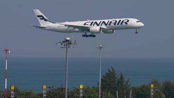 PHUKET, THAILAND - FEBRUARY 26, 2023. Airbus A350-941, OH-LWE of Finnair approaching landing at Phuket airport, side view. Travel concept video