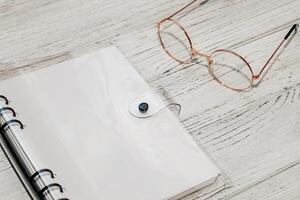 Notebook with rings, checkered sheets, transparent cover with glasses. photo