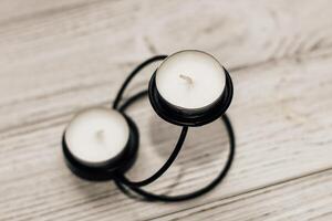 Black decorative candlestick with candles on a wooden background photo