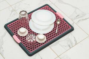 A tray with a grid for drying dishes, a convenient kitchen device. photo