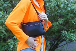 Girl's neat hands hold a handbag, details of style. photo