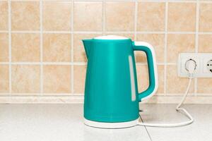 An electric bright kettle heats water in the kitchen. photo