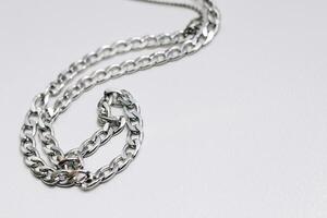 Different silver metal chains on a light background. photo