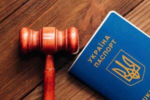 Ukrainian passport with a judge's gavel on a wooden table. photo