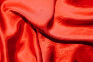 rojo brillante textura de seda satín satín con pliegues foto