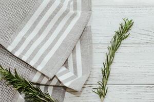 Fresh green sprig of rosemary seasoning on table with kitchen towel. photo