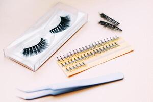 Artificial false fluffy eyelashes with tweezers. photo