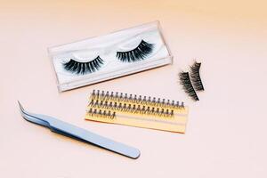 Artificial false fluffy eyelashes with tweezers. photo