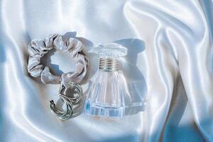 Perfume bottle and silk elastic band on a golden background, beauty routine photo