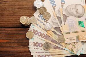 en el mesa con ucranio grivnas, cuentas y monedas foto