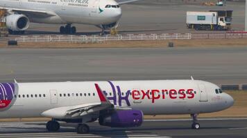 HONG KONG - NOVEMBER 10, 2019. Airbus A321-231, B-LEH of HK express speeding up for takeoff at Chek Lap Kok Airport, side view. Plane departure video