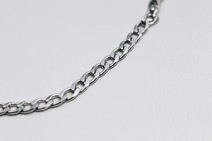 Different silver metal chains on a light background. photo