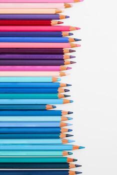 Multi-colored pencils lie on a white table, the violet range of colors photo